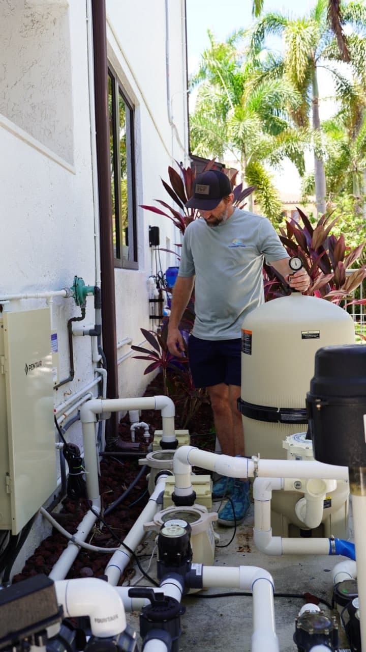 Florida's Best Pools technician inspecting pool equipment pad pumps and valves in South Florida