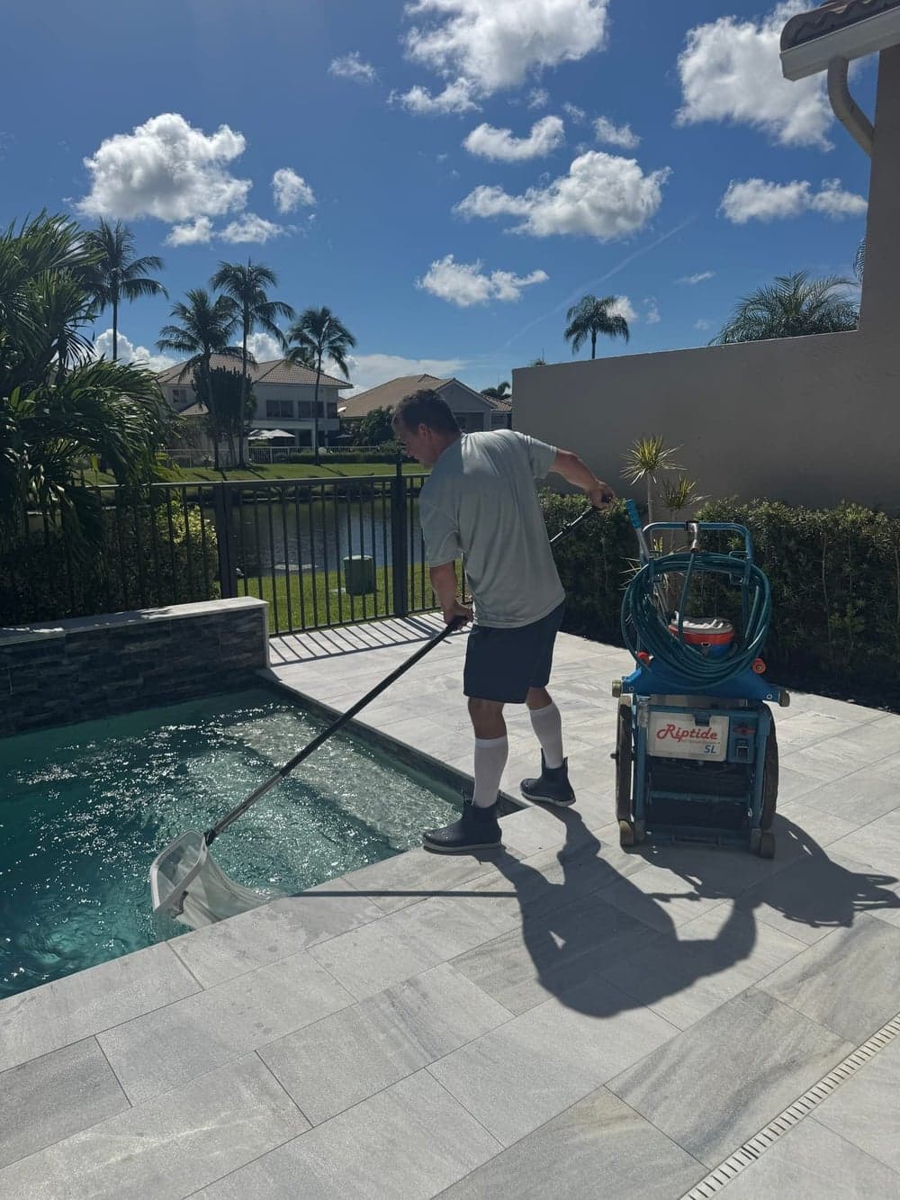 Florida's Best Pools technician vacuuming a pool during a service visit in South Florida