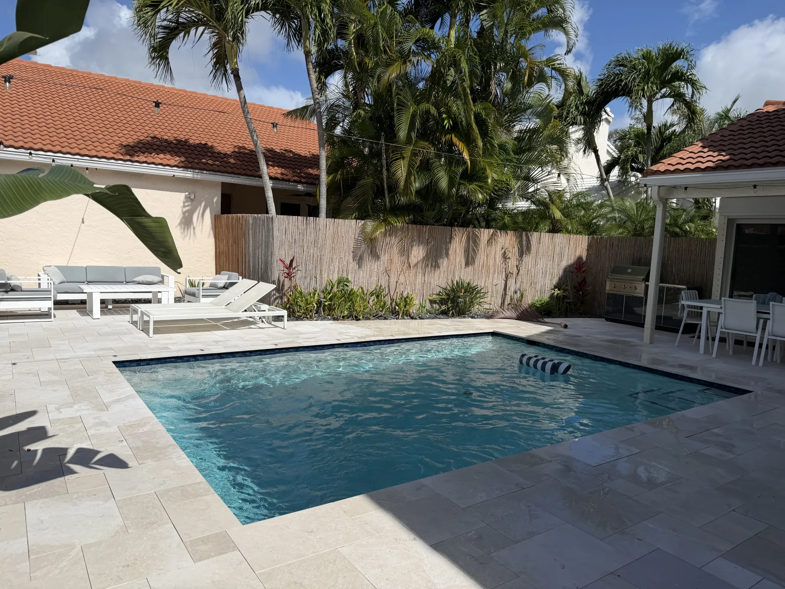 Crystal-clear Delray Beach residential pool after a full route turnaround — balanced chemistry, brushed tile, photo-documented service log on a Florida's Best Pools weekly route