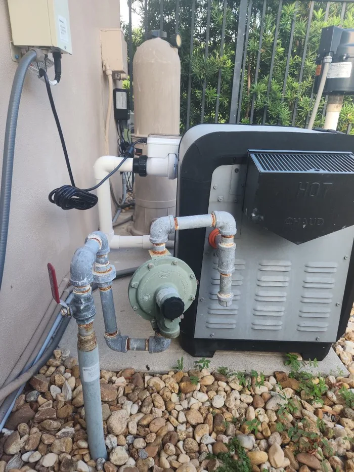 A gas pool heater installed on a Boca Raton equipment pad — the fast-heat option that earns its keep on spas and hot tubs and works in any weather